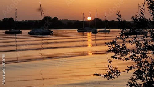 Beautiful sunset above sail boats anchoring in a harbor.