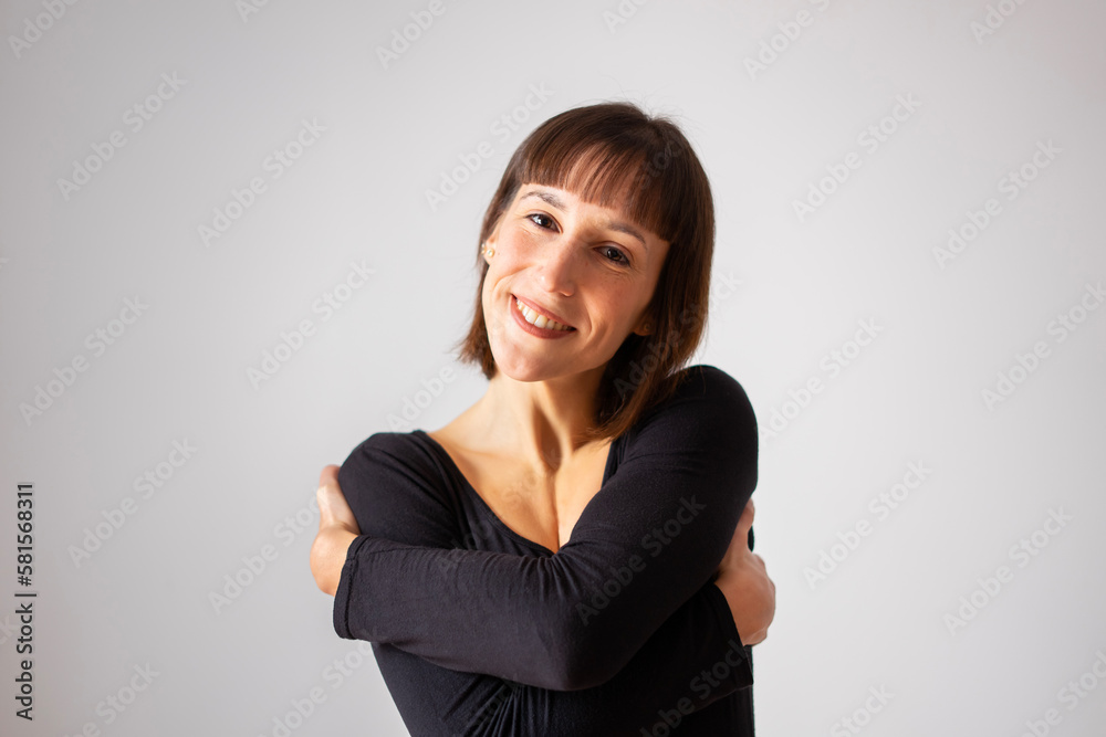Portrait of a girl on white background. Brown short hair girl. Happy girl hugging herself. Portrait of a girl on white background. Brown short hair girl. Happy girl hugging herself.