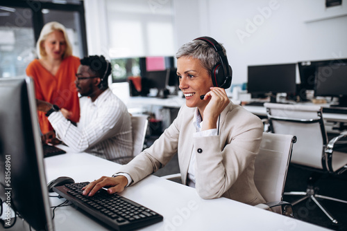 Team of call center employees working together in office.