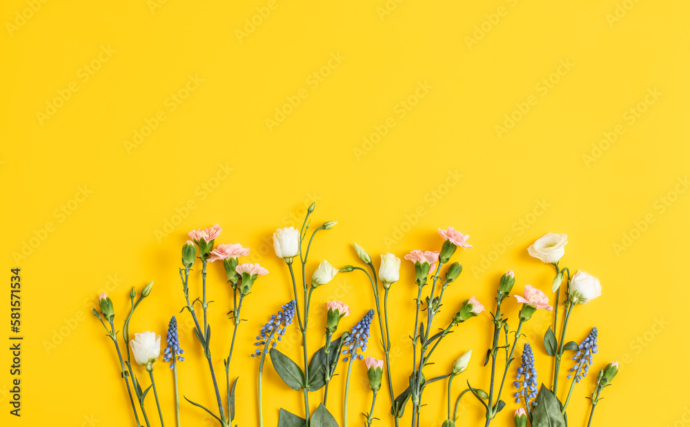 Flowers composition on a bright yellow trendy background. Floral background. Backdrop for Mother’s Day. Text space  - obrazy, fototapety, plakaty 