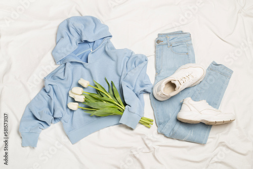 Stylish pastel spring outfit on white sheet background, top view