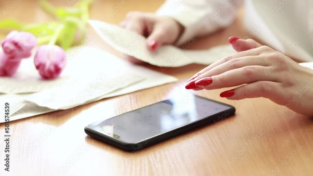 Woman calculates financial expenses, keeps track of purchases by checks, manages a family home budget plan. Women's hands and a calculator on the phone. The girl calculates the amount of purchases Woman calculates financial expenses, keeps track of purchases by checks, manages a family home budget plan. Women's hands and a calculator on the phone. The girl calculates the amount of purchases