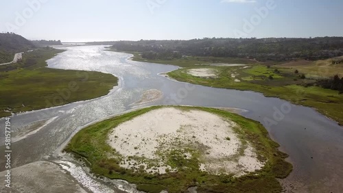 stunning aerial footage of Batiquitos Lagoon surrounded by lush green trees and plants with blue sky and clouds and palm trees in Carlsbad California USA photo