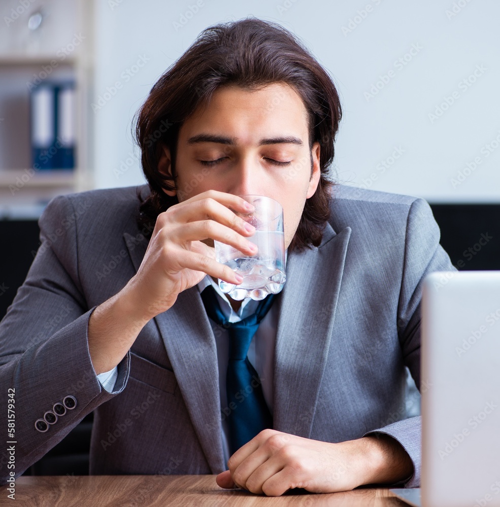 Sick male employee suffering in the office Sick male employee suffering in the office