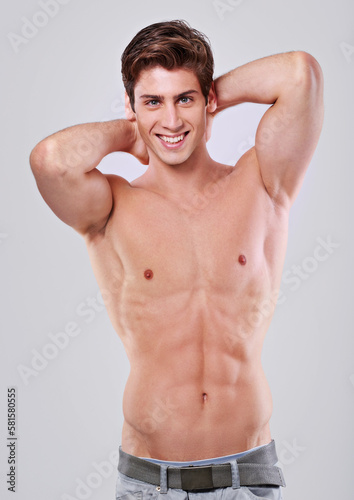 Im all man. Studio shot of a handsome bare chested young man with his hands behind his head. photo