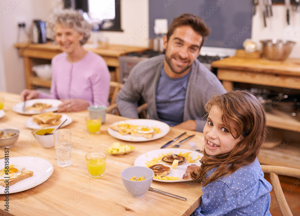 Enjoying a yummy breakfast. a family eating breakfast around the kitchen table.