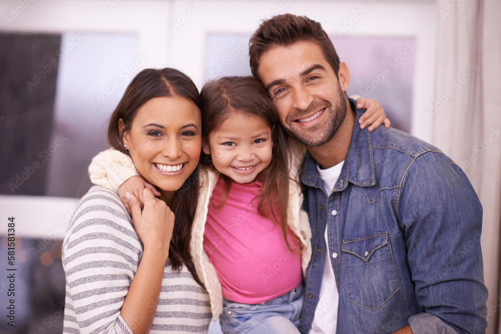 Treasured moments with family. Portrait of a happy young family sitting together at home. Treasured moments with family. Portrait of a happy young family sitting together at home.