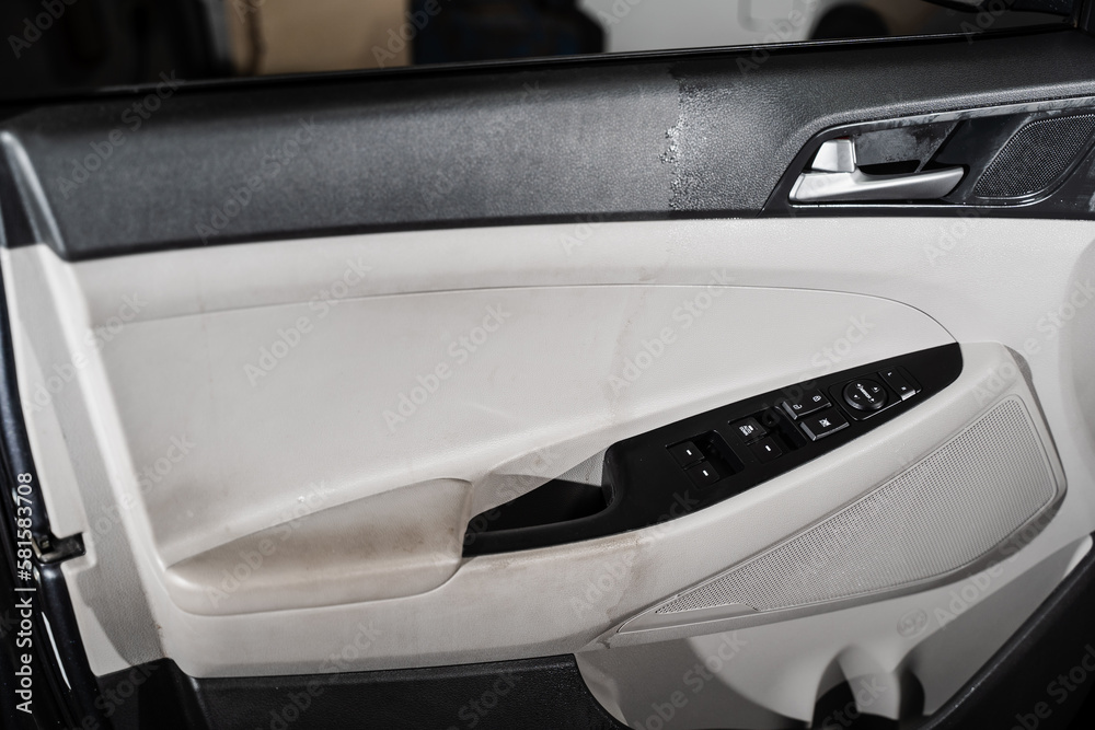 Half of car door panel with dirty and dust, other half of car door card