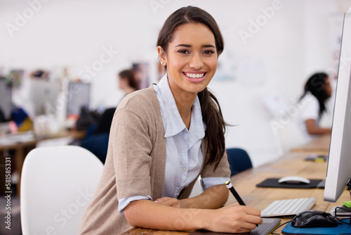 She lives by the company brand. a beautiful young businesswoman sitting at her desk.