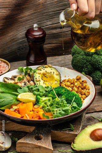 vegetable vegetarian buddha bowl avocado, mushrooms, broccoli, spinach, chickpeas, pumpkin on a wooden background. top view