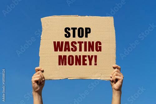 фотографія Stop wasting money text on box paper held by 2 hands with isolated blue sky background