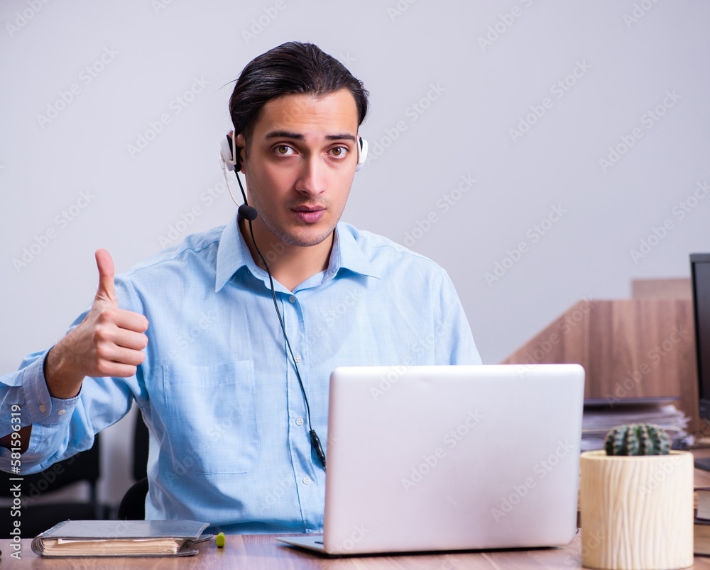 Call center operator working at his desk Call center operator working at his desk