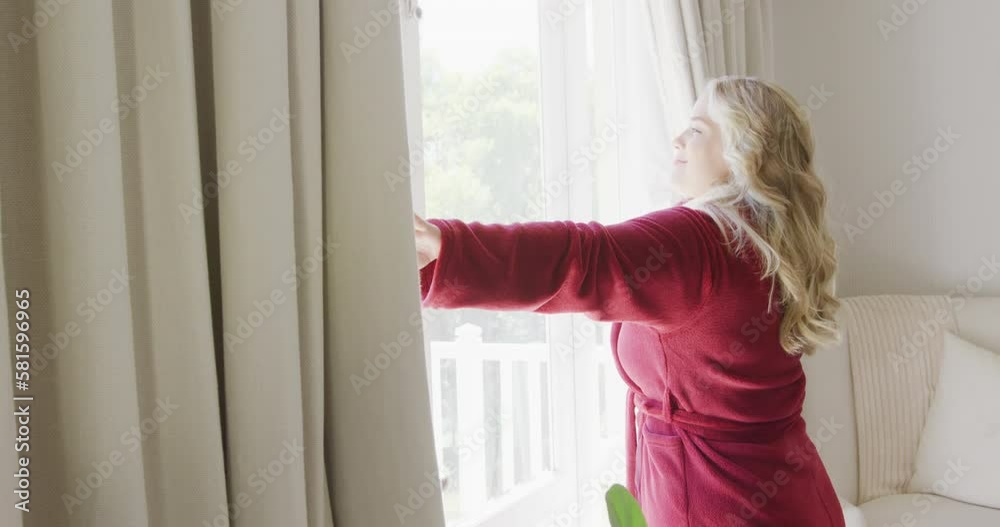 Happy caucasian plus size woman uncovering windows with curtain in slow motion Happy caucasian plus size woman uncovering windows with curtain in slow motion