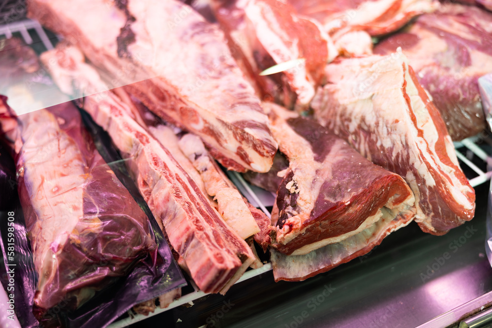 Piece of raw frozen beef lies in butcher shop window