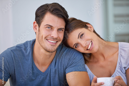 Carefree day together. Closeup portrait of an affectionate young couple relaxing at home with coffee.