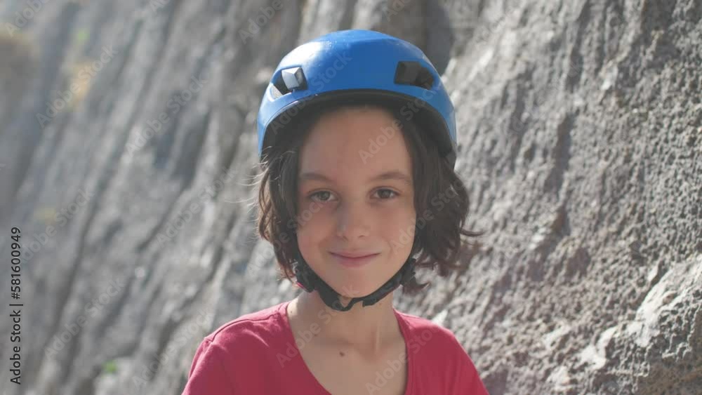 portrait of a smiling child rock climber in a hard hat. playing sports in nature. portrait of a smiling child rock climber in a hard hat. playing sports in nature.