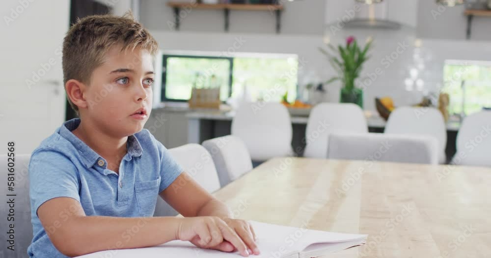 Caucasian boy sitting at table and reading braille, slow motion Caucasian boy sitting at table and reading braille, slow motion