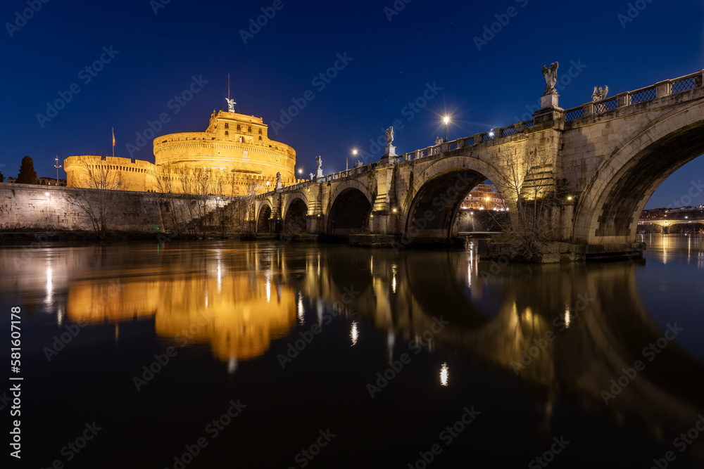 Bridge and castle Sant Angelo and Tiber river at night with city lights in Rome,Italy