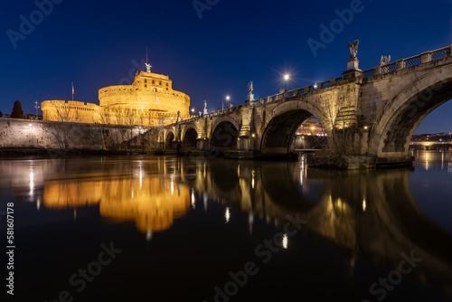 Bridge and castle Sant Angelo and Tiber river at night with city lights in Rome,Italy