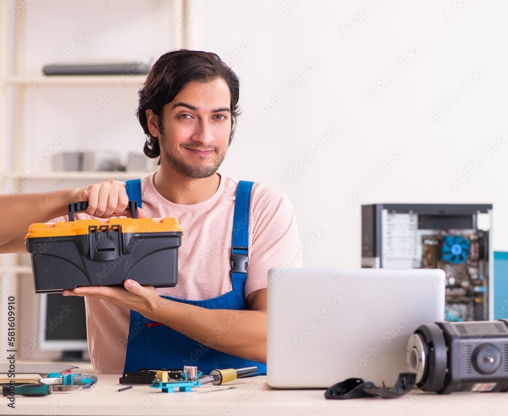 Young male contractor repairing computer Young male contractor repairing computer