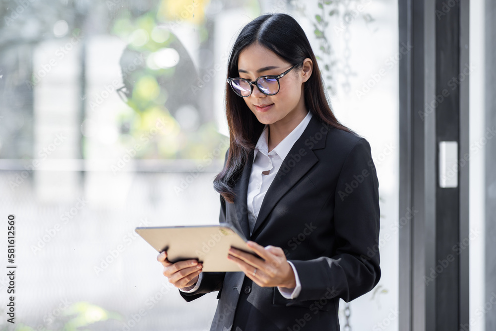 Portrait of Young business asian woman using tablet, standing in office.
Portrait of Young business asian woman using tablet, standing in office.