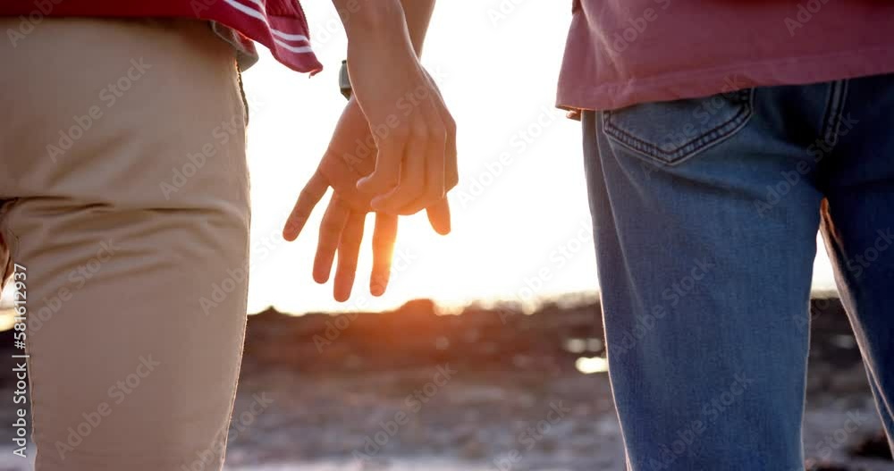 Midsection of diverse gay male couple holding hands at beach, slow motion Midsection of diverse gay male couple holding hands at beach, slow motion