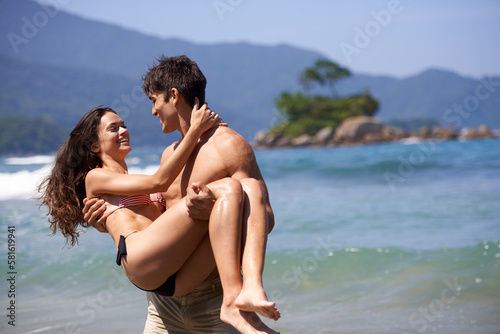 Carrying her over the threshold. a young couple enjoying a beach getaway.