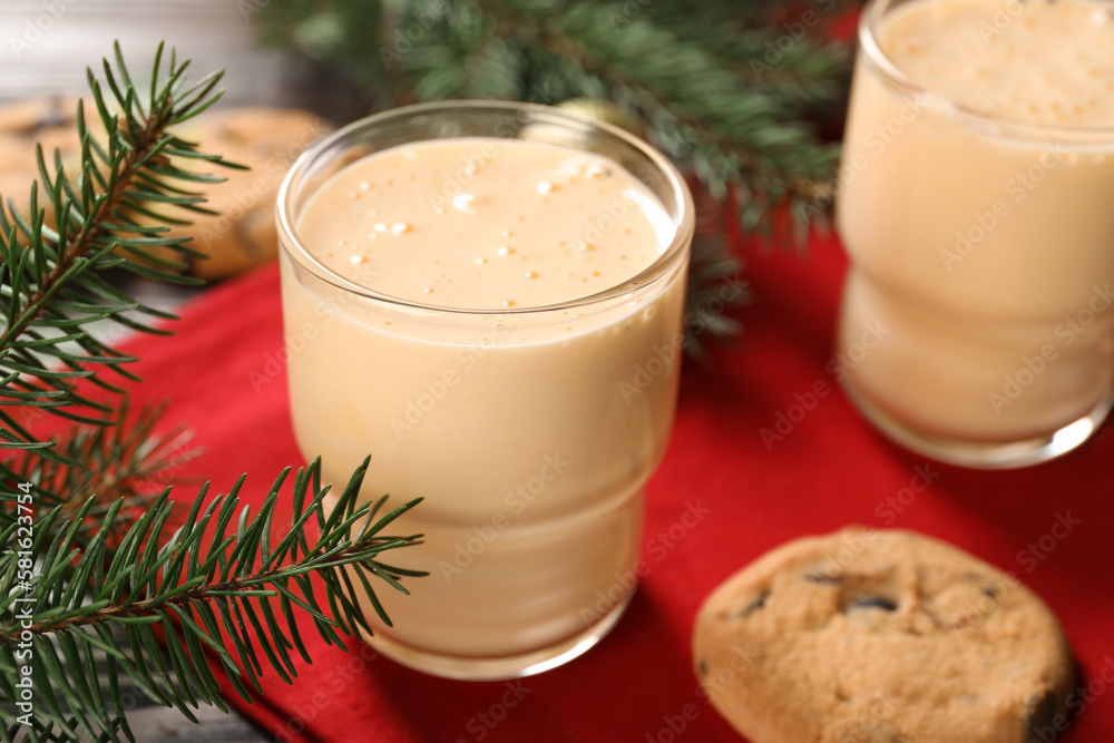 Tasty eggnog, cookies and fir branches on wooden table, closeup Tasty eggnog, cookies and fir branches on wooden table, closeup