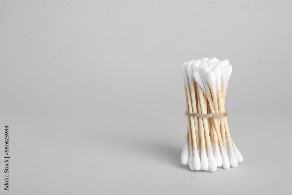 Bunch of wooden cotton buds on light grey background. Space for text Bunch of wooden cotton buds on light grey background. Space for text