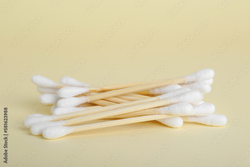 Many wooden cotton buds on beige background Many wooden cotton buds on beige background
