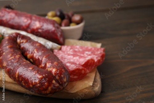 Different types of tasty sausages on wooden table, closeup. Space for text