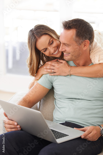 I need to show you this email. a married couple using their laptop at home. © AW/peopleimages.com