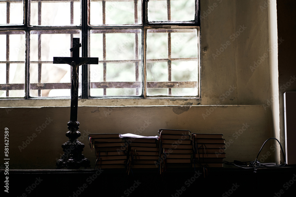Window in the church, with cross and Bible books.