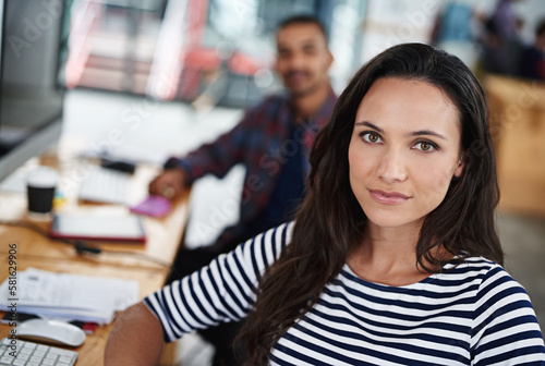 Make creativity a job. Portrait of two smiling coworkers sitting at their computers.