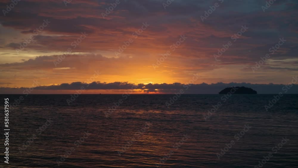 Majestic Dramatic Sunset Sky by the Ocean. Slow zoom in on sun disk setting over the sea hiding behind clouds near horizon line. Majestic Dramatic Sunset Sky by the Ocean. Slow zoom in on sun disk setting over the sea hiding behind clouds near horizon line.