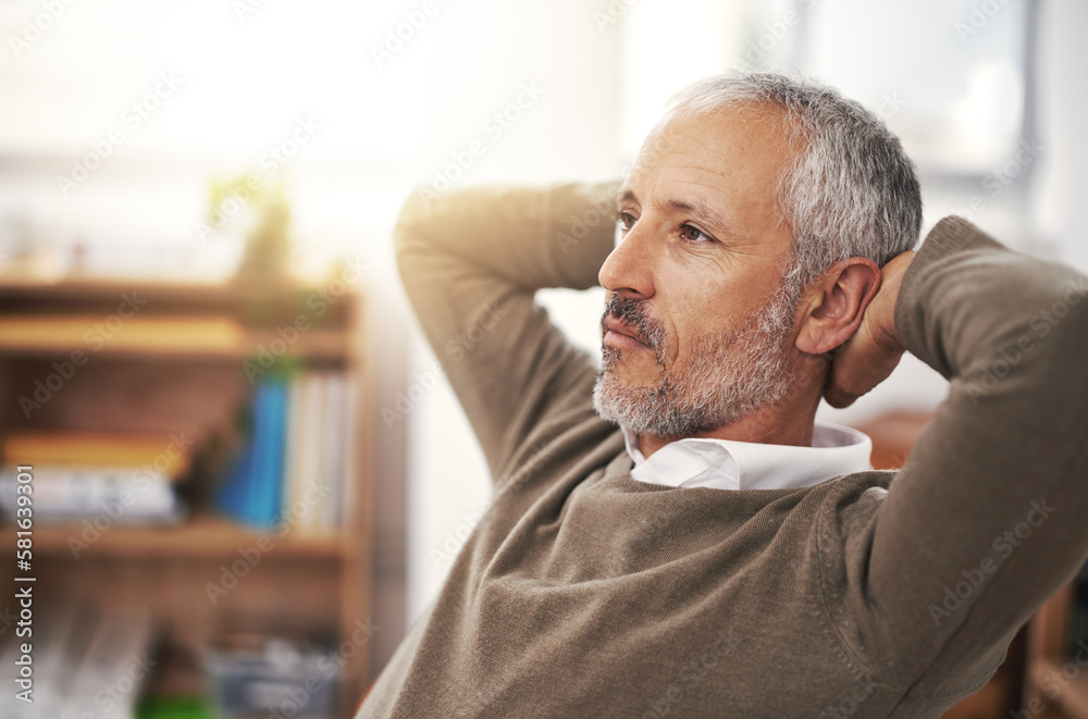 Obraz premium Thinking about the future of his company. a businessman sitting with his hands behind his head at his desk.
