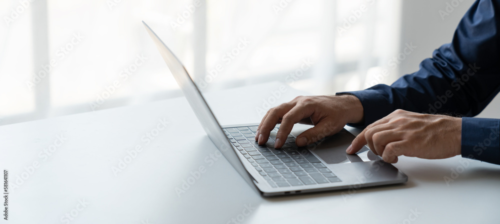businessman working in a private room He is typing on a laptop keyboard. He uses a messenger to chat with colleagues in an online business. concept of using technology in communication. businessman working in a private room He is typing on a laptop keyboard. He uses a messenger to chat with colleagues in an online business. concept of using technology in communication.