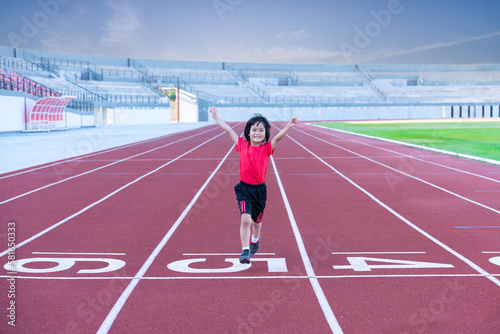 Little girl at athletics competition race. A girl running in stadium.