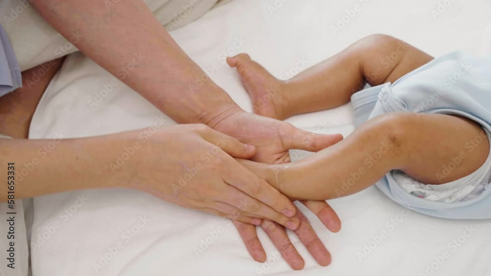 mother applying moisturizing cream on foot of her newborn baby mother applying moisturizing cream on foot of her newborn baby