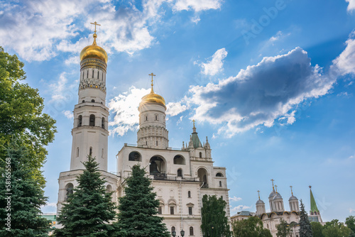 Ivan the Great Bell Tower, with Assumption Belfry on the right in Moscow Kremlin. Blue sky background with sunbeams