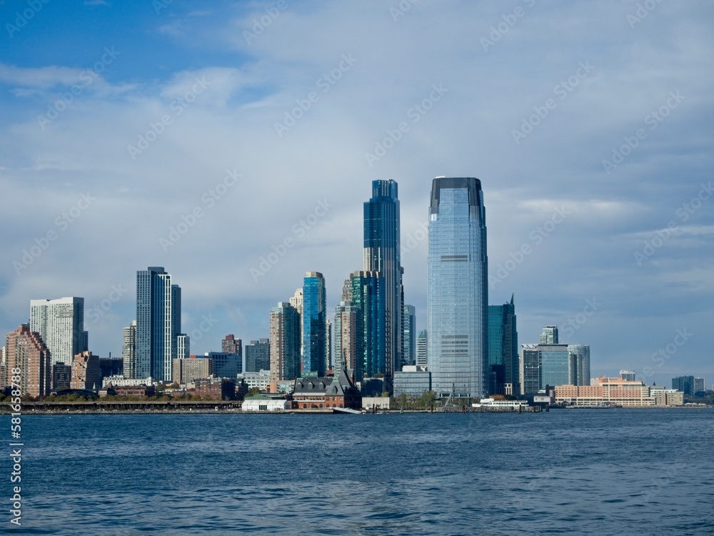 Looking back on Manhattan from the Hudson River and Liberty Island, as the towering high rises of Lower Manhattan loom above the river