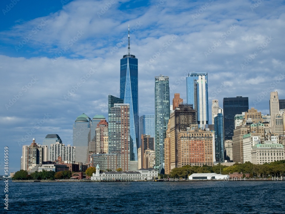 Obraz premium Looking back on Manhattan from the Hudson River and Liberty Island, as the towering high rises of Lower Manhattan loom above the river