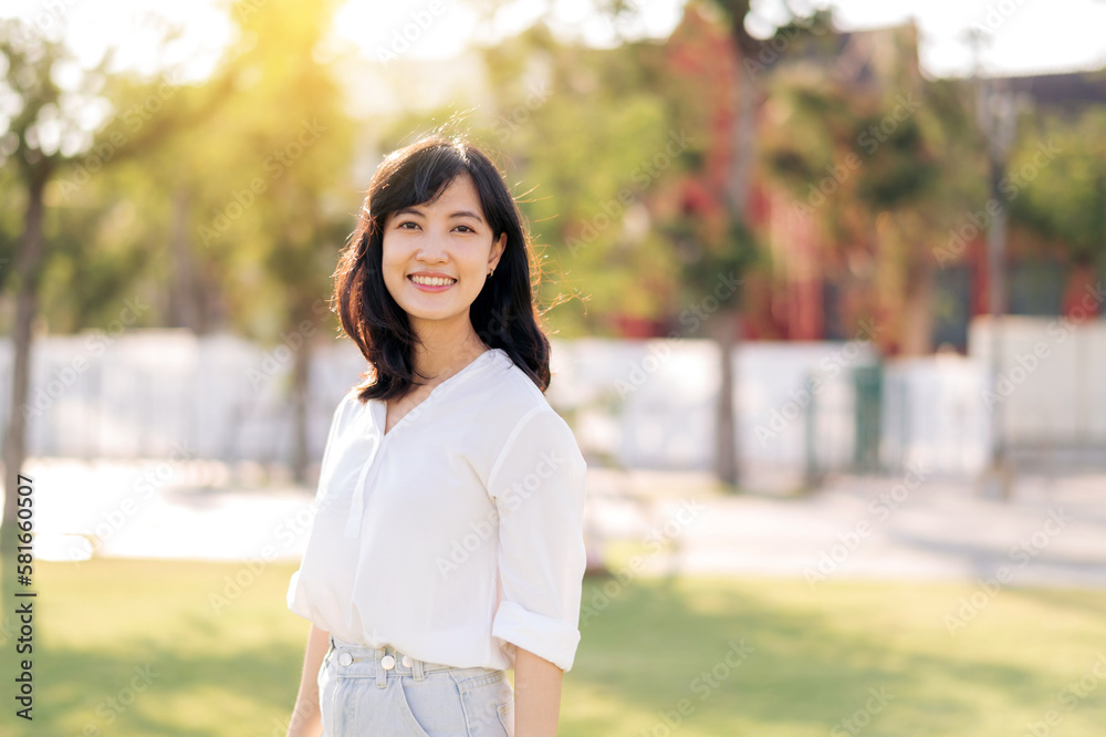 Portrait young beautiful asian woman with happy smile around outdoor park in sunny summer day Portrait young beautiful asian woman with happy smile around outdoor park in sunny summer day
