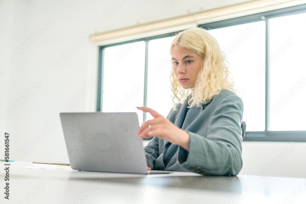 Focused on success and growth , Pretty young business woman working with computer while consulting some invoices and documents. Focused on success and growth , Pretty young business woman working with computer while consulting some invoices and documents.