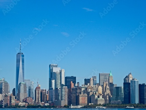 Looking back on Manhattan from the Hudson River and Liberty Island, as the towering high rises of Lower Manhattan loom above the river