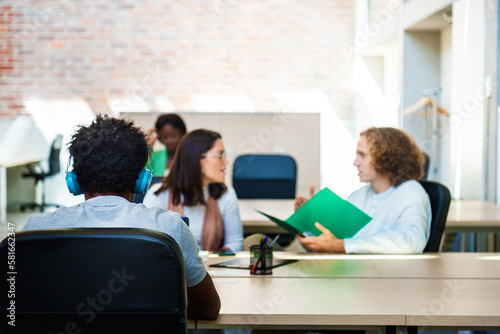 Multiracial employees in office space working. Blurred background. Copy space.