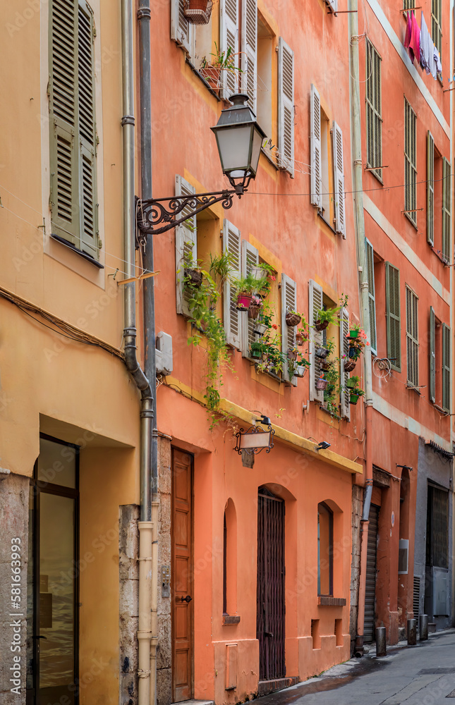 Facades of traditional mediterranean houses with flower pots in the streets Old Town of Nice, France