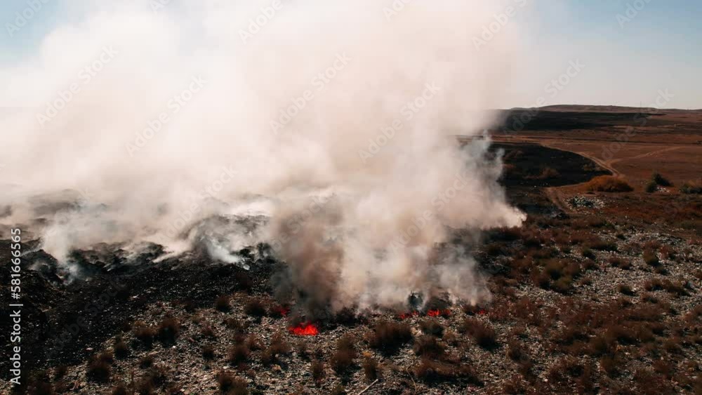 Aerial view of big smoke clouds and fire on the field. Flying over wildfire and plumes of smoke. Forest and tropical jungle deforestation. Amazon and siberian wildfires. Natural disaster. Climate Aerial view of big smoke clouds and fire on the field. Flying over wildfire and plumes of smoke. Forest and tropical jungle deforestation. Amazon and siberian wildfires. Natural disaster. Climate