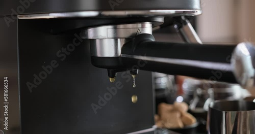 Water drops from a coffee machine filter holder at the end of espresso preparation process photo