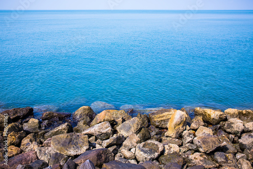 The beach and sea surface with Deep Blue sea clear sky clouds. Landscape with Ocean small waves water reflection copy space for text. Illustration for tourism, website or ad. Andaman sea, Thailand.